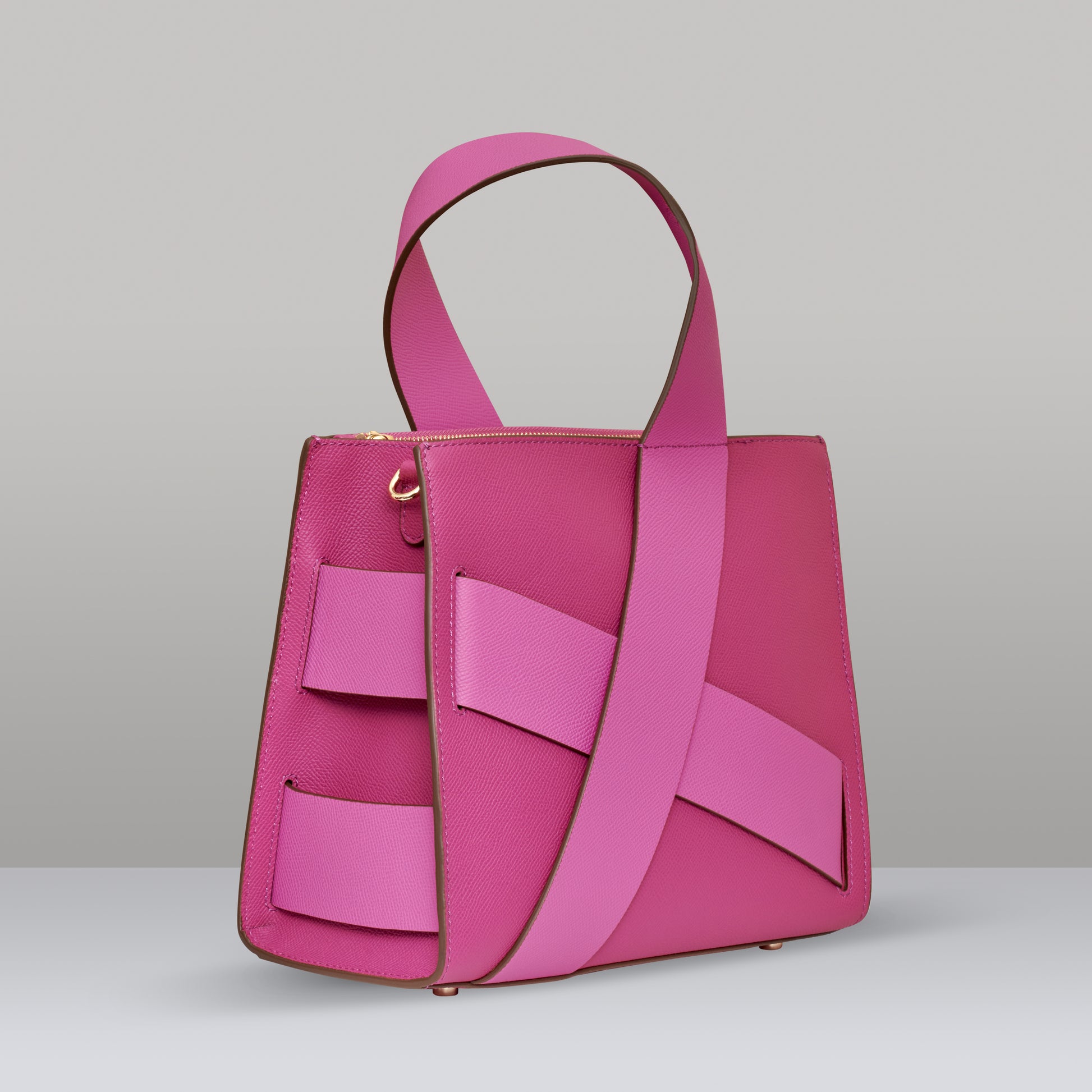 Side view of pink leather Diagonal Zita Bag with unique crossing straps