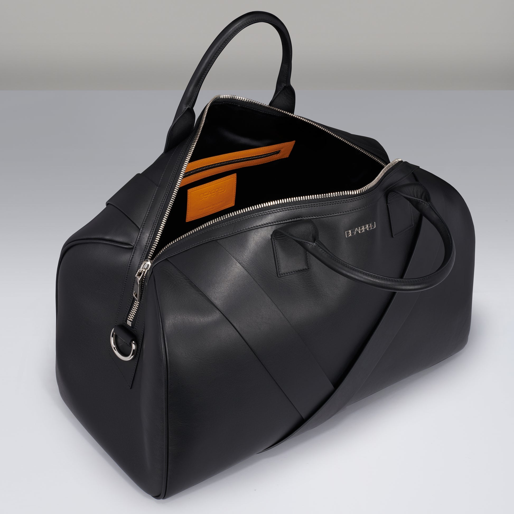 Side view of black leather Travel Duffle Bag with sturdy handles